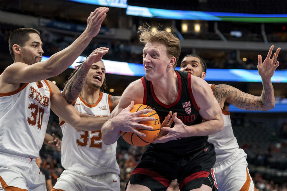 Stanford forward James Keefe struggles to retain possession as Texas forwards Brock Cunningham (30), Christian Bishop (32) and Timmy Allen close in during the second half of an NCAA college basketball game, Sunday, Dec. 18, 2022, in Dallas. Texas won 72-62. (AP Photo/Jeffrey McWhorter)