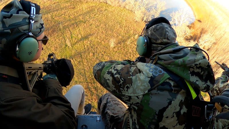 Texas A&M University student Mitchell Birkitt and another hunter shoot at feral hogs from a helicopter in Bryan