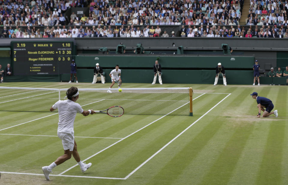 Roger Federer of Switzerland, left, returns a ball to Novak Djokovic of Serbia during the men's singles final at the All England Lawn Tennis Championships in Wimbledon, London, Sunday July 12, 2015. (AP Photo/Pavel Golovkin)
