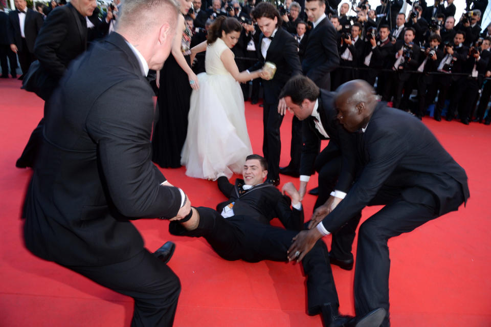 Sediuk being pulled away by security guards after climing under Ferrera's dress. (Photo: Getty Images)