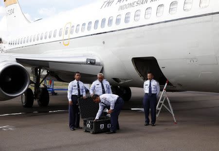 An Indonesian Air Force flight crew waits to receive the flight data recorder from AirAsia QZ8501 for transport back to Jakarta at the airbase in Pangkalan Bun, Central Kalimantan January 12, 2015. REUTERS/Darren Whiteside