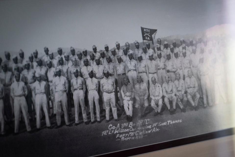 A photograph of a platoon that Corporal William Henry Micou, 99, served with during World War II hangs above his bed at American House Senior Living in Farmington Hills on Monday, August 21, 2023.