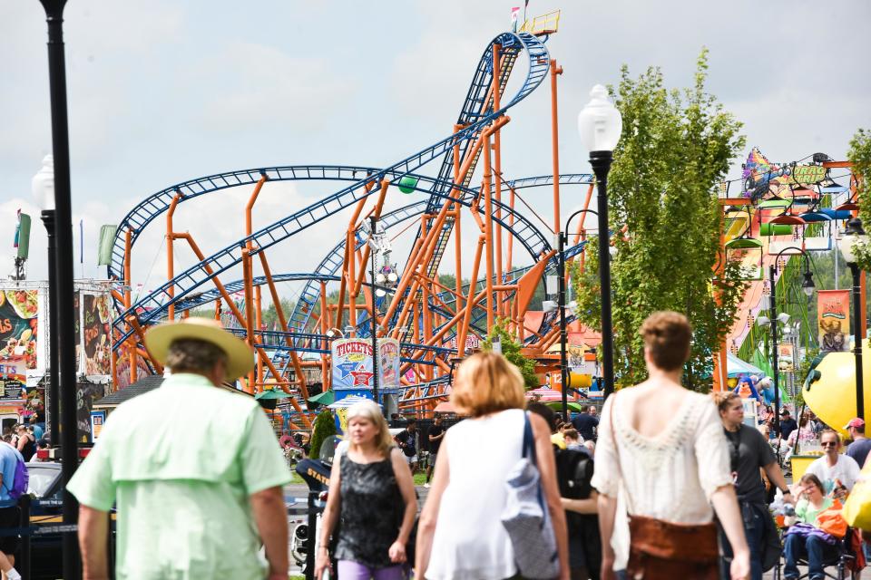 Fair-goers walk around near rides and attractions during opening day at the Great New York State Fair last year in Geddes.