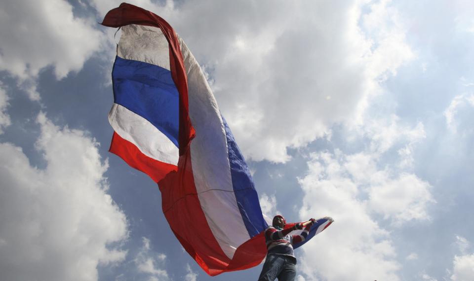 An anti-government protester waves a Thai national flag during a rally Saturday, May 10, 2014, in Bangkok, Thailand. The protesters achieved a partial victory on Wednesday when the Constitutional Court ousted Prime Minister Yingluck Shinawatra, saying she had violated the constitution by transferring a senior civil servant to benefit her politically powerful family. Nine other Cabinet members were also forced from their posts. (AP Photo/Sakchai Lalit)