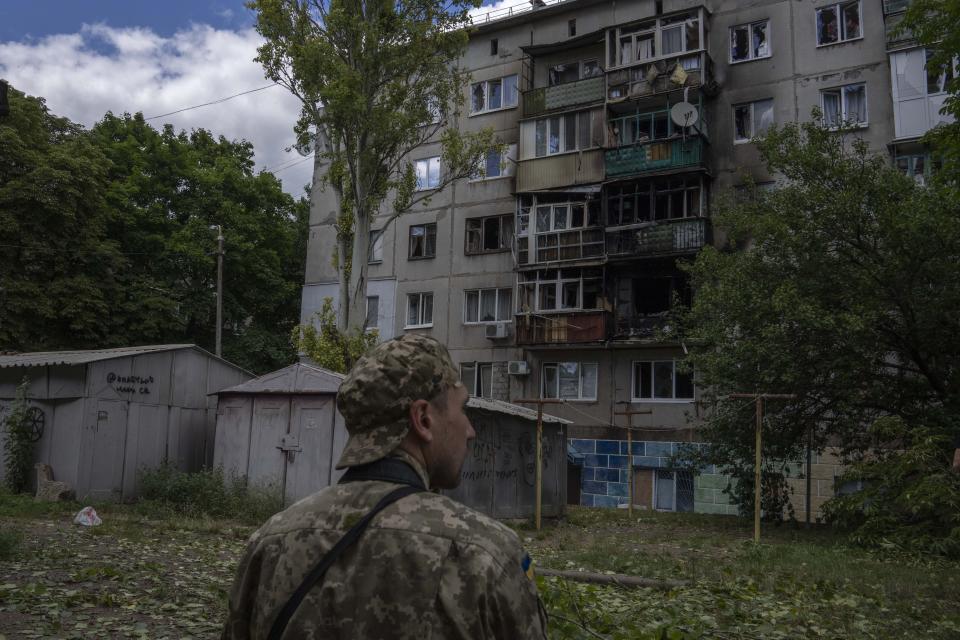 A Ukrainian soldier looks at five-story residential building damaged from a rocket attack on a residential area, in Kramatorsk, eastern Ukraine, Tuesday, July 19, 2022. (AP Photo/Nariman El-Mofty)