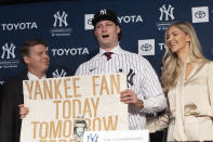 New York Yankees pitcher Gerrit Cole, center, holds a sign he used as a young Yankees fan, as he is introduced as the baseball clubs newest player during a baseball media availability, Wednesday, Dec. 18, 2019 in New York. He is joined by team owner Hal Steinbrenner, left, and his wife, Amy Cole. (AP Photo/Mark Lennihan)