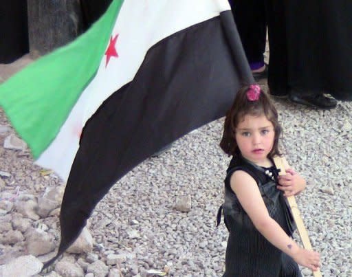 A handout picture released by the Shaam News Network purportedly shows a Syrian girl carrying the old national flag, adopted by the opposition, during an anti-regime demonstration in Daraa on April 22. United Nations ceasefire monitors were touring towns near the Syrian capital, an official said, as the European Union slapped new sanctions on the regime of Bashar al-Assad