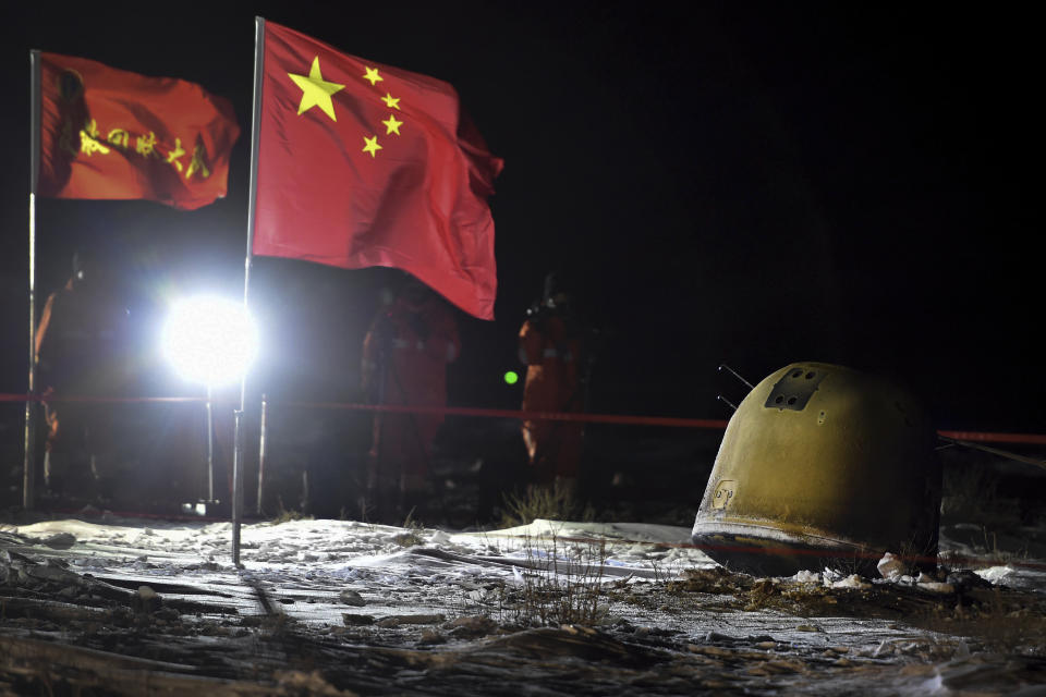 In this photo released by Xinhua News Agency, recovery crew members film the capsule of the Chang'e 5 probe after its successful landed in Siziwang district, north China's Inner Mongolia Autonomous Region on Thursday, Dec. 17, 2020. A Chinese lunar capsule returned to Earth on Thursday with the first fresh samples of rock and debris from the moon in more than 40 years. (Ren Junchuan/Xinhua via AP)