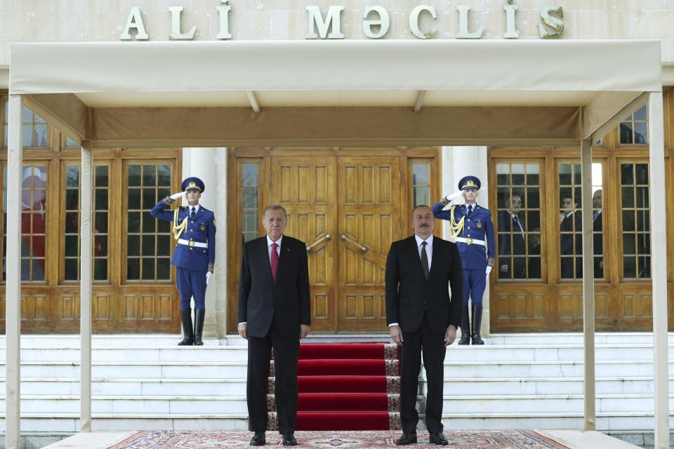 In this handout photo released by Turkish Presidency, Azerbaijan's President Ilham Aliyev, right, and Turkey's President Recep Tayyip Erdogan listen to national anthems during a welcome ceremony in Nakhchivan, Azerbaijan, Monday, Sept. 25, 2023. Thousands of Armenians streamed out of Nagorno-Karabakh after the Azerbaijani military reclaimed full control of the breakaway region while Turkish President Recep Tayyip Erdogan visited Azerbaijan Monday in a show of support to its ally. (Turkish Presidency via AP)