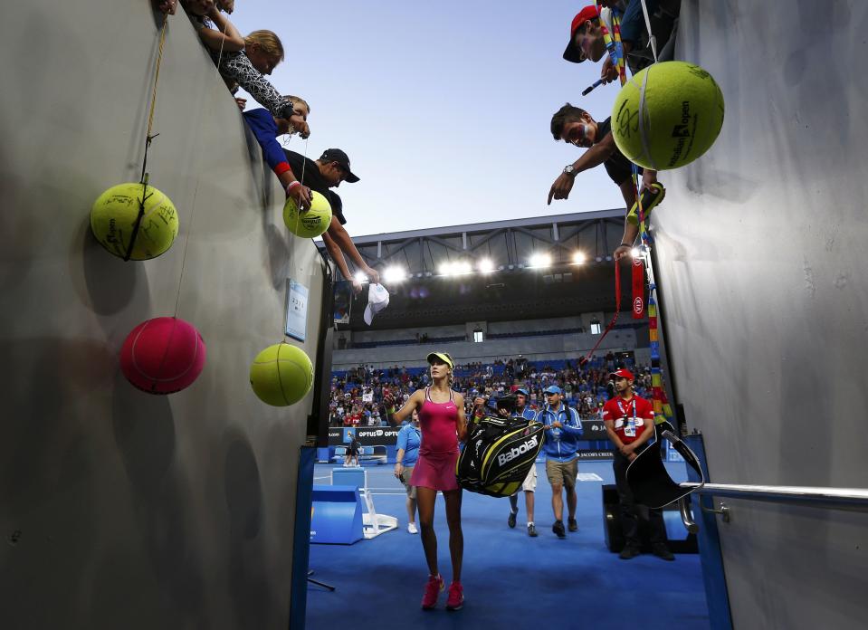 Eugenie Bouchard of Canada prepares to sign autographs while walking off court, after defeating Anna-Lena Friedsam of Germany in their women's singles first round match at the Australian Open 2015 tennis tournament in Melbourne January 19, 2015. REUTERS/Athit Perawongmetha (AUSTRALIA - Tags: SPORT TENNIS)