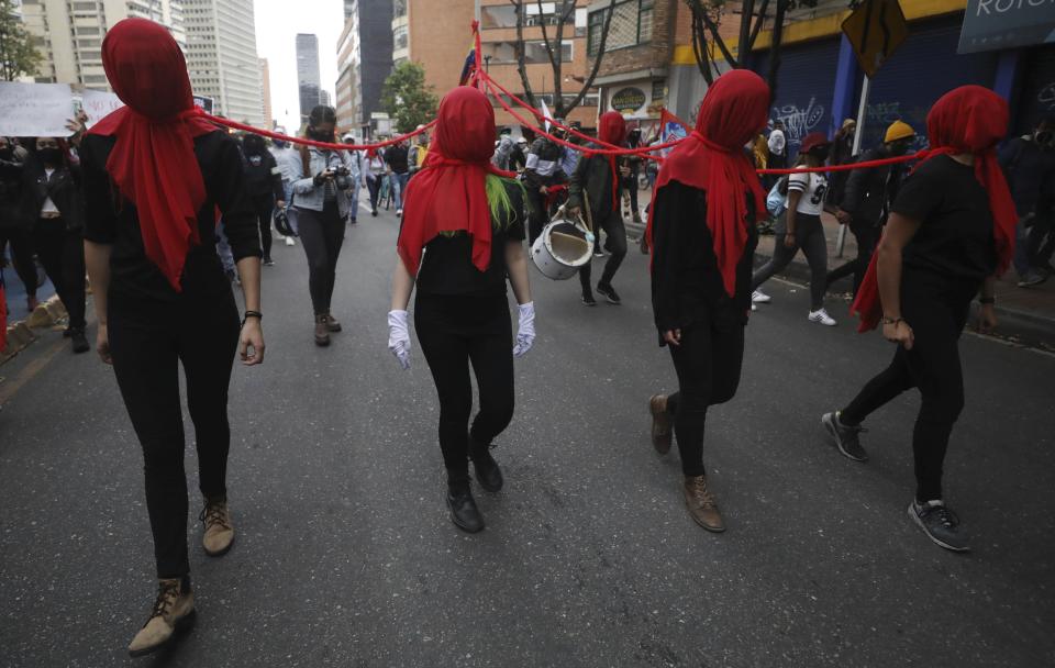 Mujeres con velos rojos participan en Bogotá durante una protesta contra la ola de masacres en diversas partes de Colombia, el lunes 21 de septiembre de 2020. (AP Foto/Fernando Vergara)