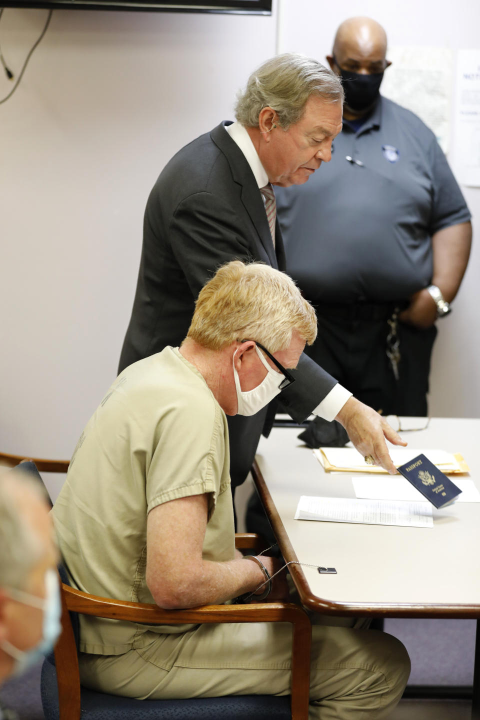 Alex Murdaugh's attorney, Dick Harpootlian, hands over Alex Murdaugh's passport during his bond hearing, Thursday, Sept. 16, 2021, in Varnville, S.C. Murdaugh surrendered Thursday to face insurance fraud and other charges after state police said he arranged to have himself shot in the head so that his son would get a $10 million life insurance payout. (AP Photo/Mic Smith)