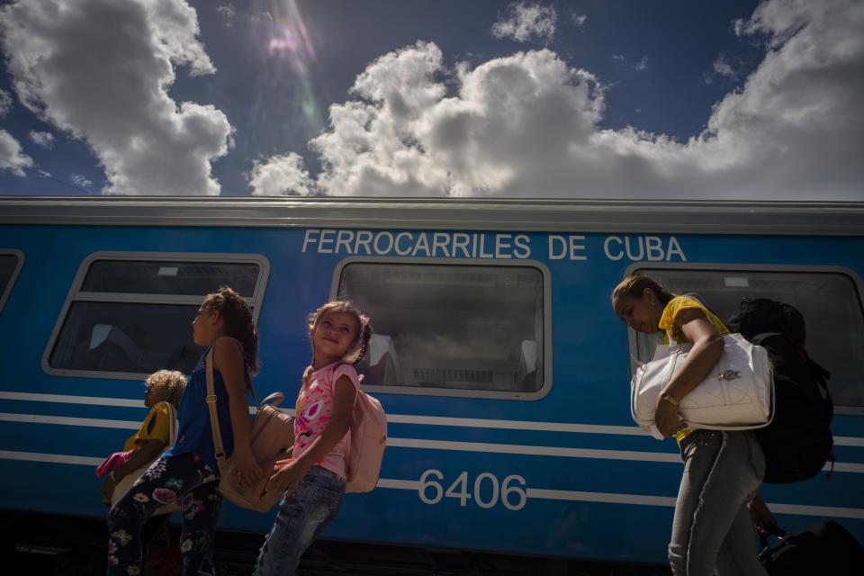 Passengers board the first train using new equipment from China , in Havana, Cuba, Saturday, July 13, 2019. The first train using new equipment from China pulled out of Havana Saturday, hauling passengers on the start of a 915-kilometer (516-mile) journey to the eastern end of the island as the government tries to overhaul the country’s aging and decrepit rail system. (AP Photo/Ramon Espinosa)