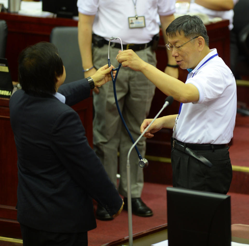 台北市議會2017年6月進行市政總質詢，台北市議員王世堅（左）質詢台北市長柯文哲（右）時，送柯文哲一只聽診器，期盼他能成為市政良醫。（資料照/劉宗龍攝）