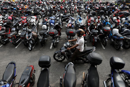 A motorist passes by motorcycles at a public carpark in Malaysia's southern city of Johor Bahru April 26, 2017. REUTERS/Edgar Su