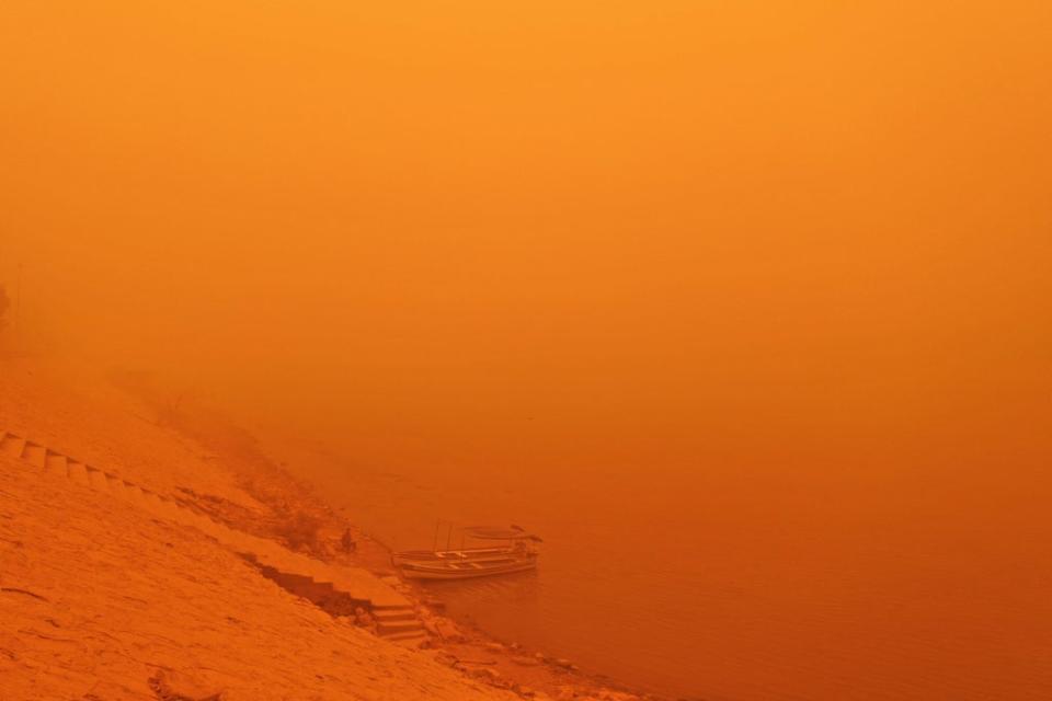 This picture taken on 16 May 2022 shows a view of the Tigris river bank in Iraq’s capital Baghdad amidst a heavy dust storm (AFP via Getty)