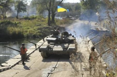 Tanks of the Ukrainian armed forces make a crossing during a withdrawal near the village of Nyzhnje in Luhansk region, Ukraine, October 5, 2015. REUTERS/Stringer