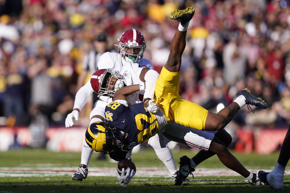 Alabama defensive back Kool-Aid McKinstry, center, tackles Michigan wide receiver Semaj Morgan (82) during the first half in the Rose Bowl CFP NCAA semifinal college football game Monday, Jan. 1, 2024, in Pasadena, Calif. (AP Photo/Ryan Sun)