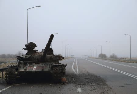 A destroyed tank is seen along a road on the territory controlled by the self-proclaimed Luhansk People's Republic near airport of Luhansk, in Luhansk region, eastern Ukraine, November 19, 2014. REUTERS/Antonio Bronic