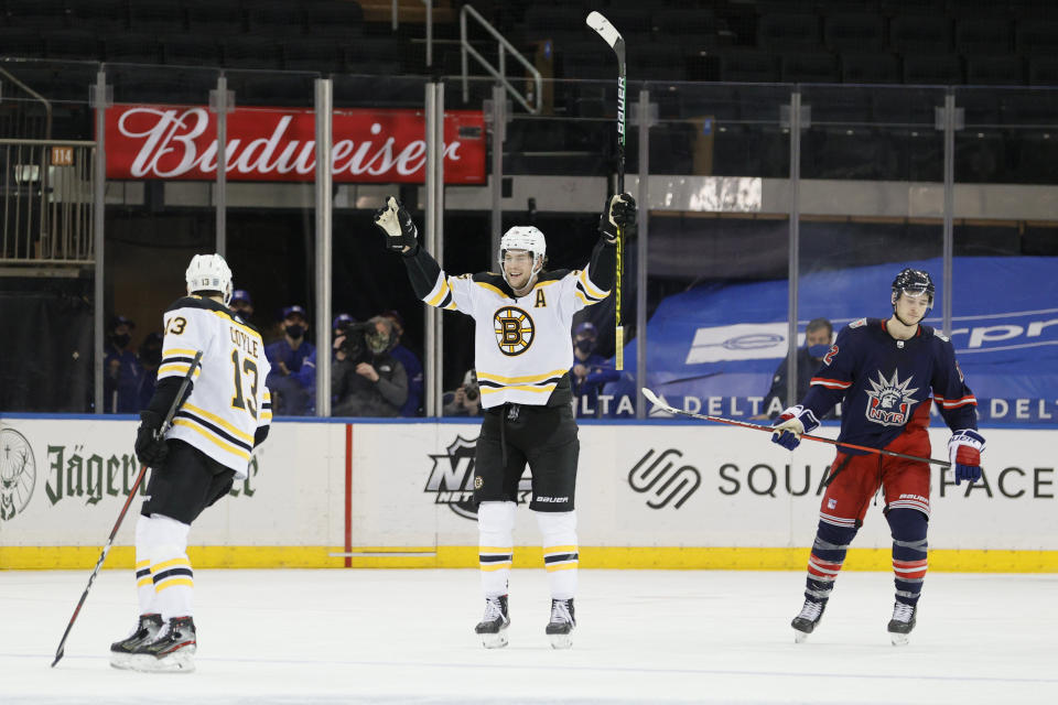 Brandon Carlo of the Boston Bruins, center, reacts after teammate Charlie Coyle, left, scores as Julien Gauthier, right, of the New York Rangers looks on during the third period of an NHL game at Madison Square Garden Sunday, Feb. 28, 2021, in New York. (Sarah Stier/Pool Photo via AP)