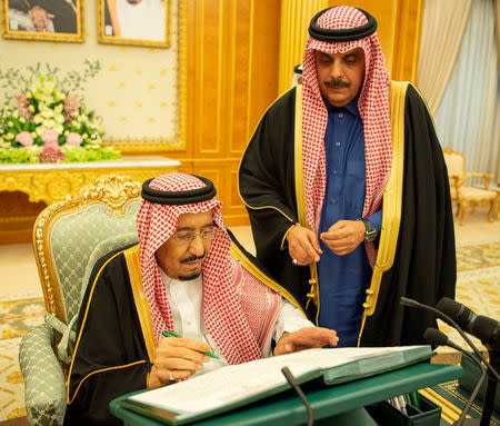 Saudi Arabia's King Salman bin Abdulaziz Al Saud signs documents during the 2019 budget meeting in Riyadh, Saudi Arabia December 18, 2018. Bandar Algaloud/Courtesy of Saudi Royal Court/Handout via REUTERS