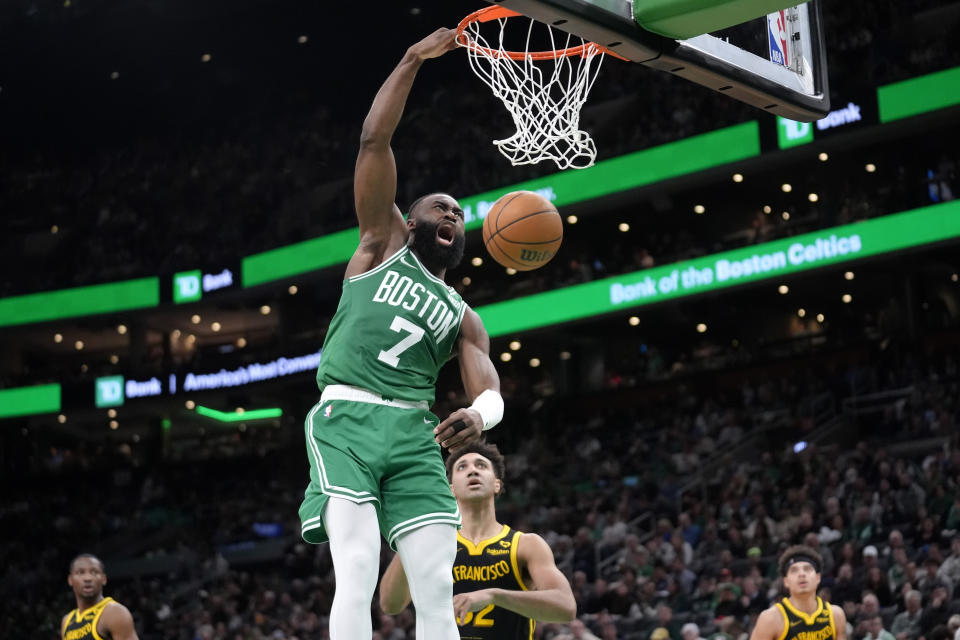 Boston Celtics guard Jaylen Brown (7) dunks the ball to score in front of Golden State Warriors forward Trayce Jackson-Davis (32) in the second half of an NBA basketball game, Sunday, March 3, 2024, in Boston. (AP Photo/Steven Senne)