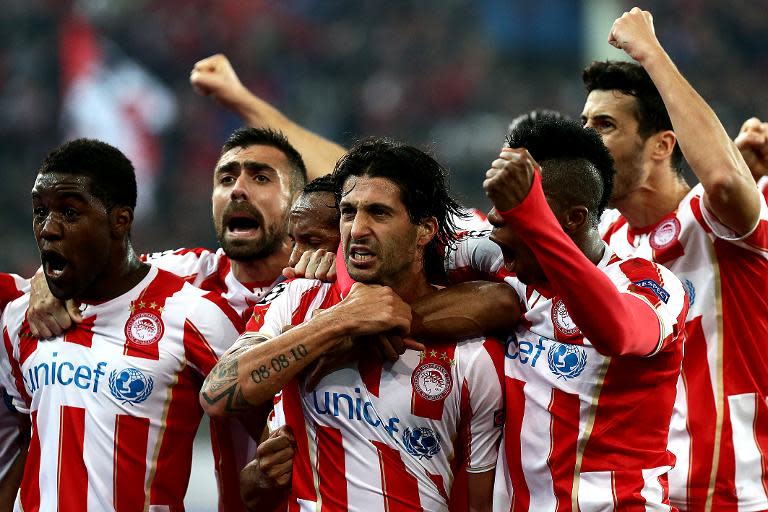 Olympiakos' Alejandro Dominguez (C) celebrates with teammates after scoring a goal during their round of 16, 1st leg UEFA Champions League match against Manchester United, at Karaiskaki Stadium in Athens, on February 25, 2014