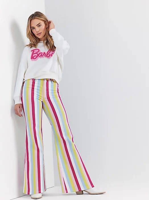 model wearing white and pink pullover with pink, blue, yellow and white striped pants
