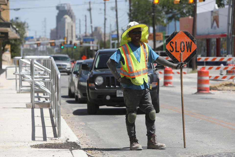 Anthony Harris stops traffic as he works with E-Z Bel Construction along Fredericksburg Road during an excessive heat warning in San Antonio, Texas, U.S. July 19, 2022.  REUTERS/Lisa Krantz