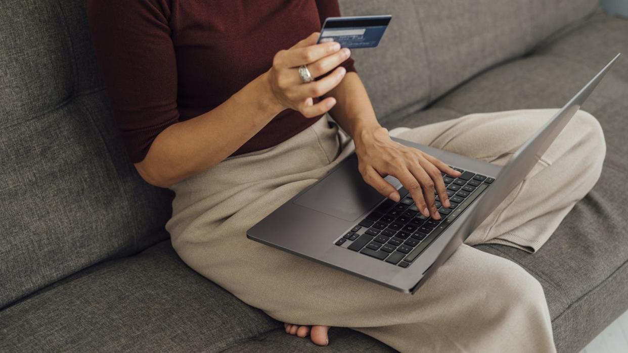 woman with credit card and laptop at home