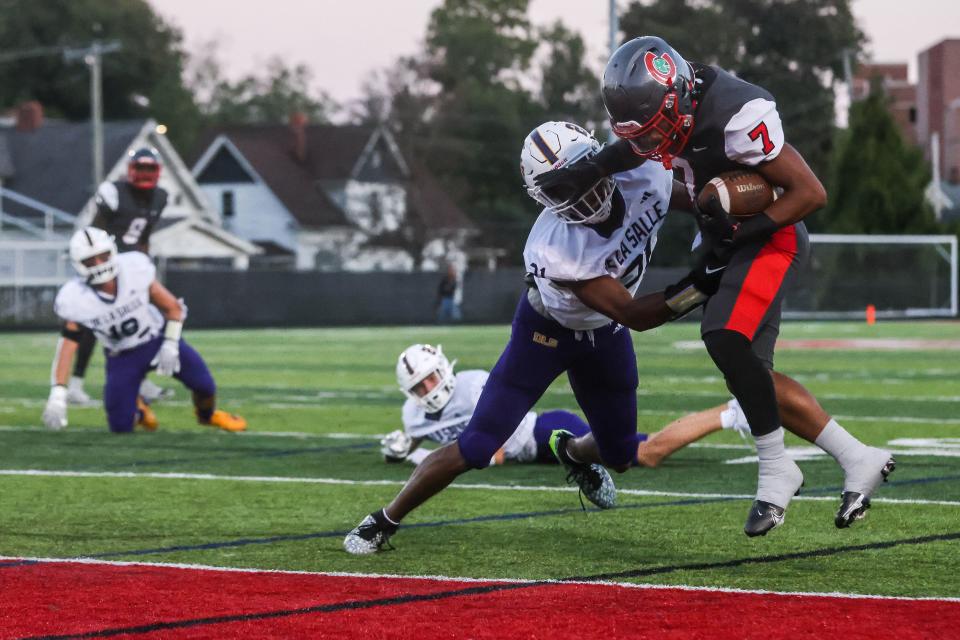 Central Catholic Fighting Irish running back Tyler Morgan (7) fights into the end zone against the Warren De La Salle Pilots in a Catholic High School League football game at Gallagher Stadium on Sept. 15, 2023 in Toledo.