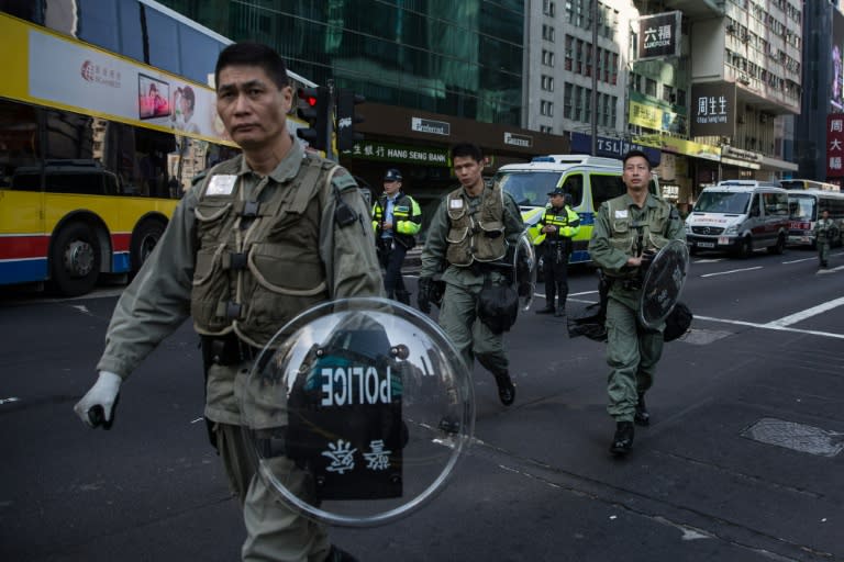 Hong Kong riot police walk along a cordoned-off street following overnight clashes with protesters in the Mongkok area of the city on February 9, 2016