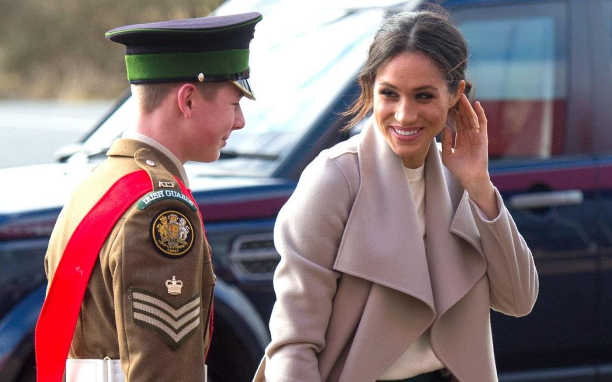 Meghan Markle grins at a young soldier at the Eikon Centre in Belfast - Splash News