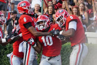 Georgia linebacker Jamon Dumas-Johnson (10) celebrates with defensive back Jalen Kimber (6) and linebacker MJ Sherman (8) after returning an interception for a touchdown during the second half of an NCAA college football game against UAB, Saturday, Sept. 11, 2021, in Athens, Ga. (AP Photo/John Bazemore)