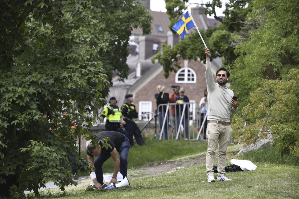 Protestor Salwan Momika waves the Swedish flag outside the Iraqi embassy in Stockholm, Thursday, July 20, 2023, where he plans to burn a copy of the Quran and the Iraqi flag. (Oscar Olsson/TT via AP)