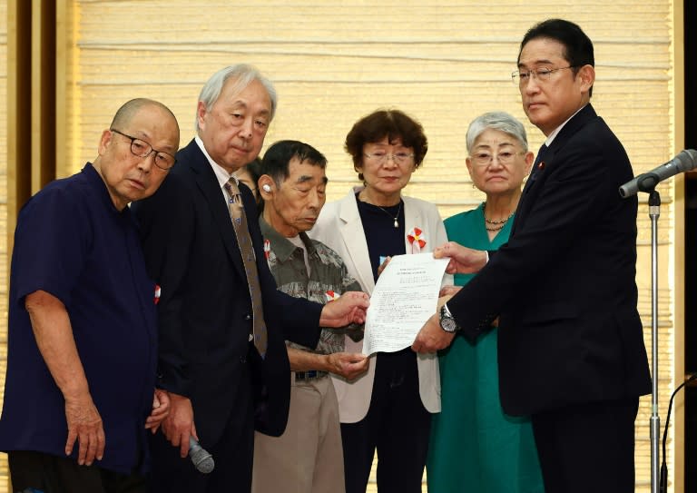 El primer ministro de Japón, Fumio Kishida (drcha.), recibe una carta de los demandantes por la ley de esterilizaciones forzadas, el 17 de julio de 2024 en Tokio (Str)