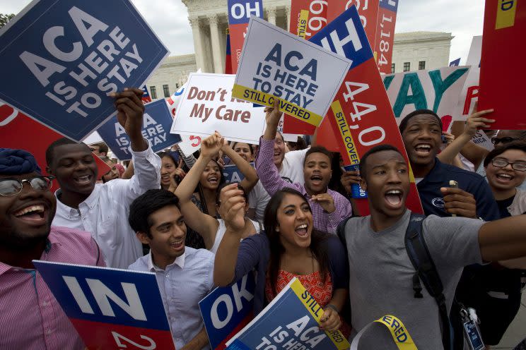 Students cheer as they hold up signs supporting the Affordable Care Act (ACA) after the Supreme Court decided that the ACA may provide nationwide tax subsidies, outside Supreme Court in Washington on June 25, 2015. (Photo: AP/Jacquelyn Martin)