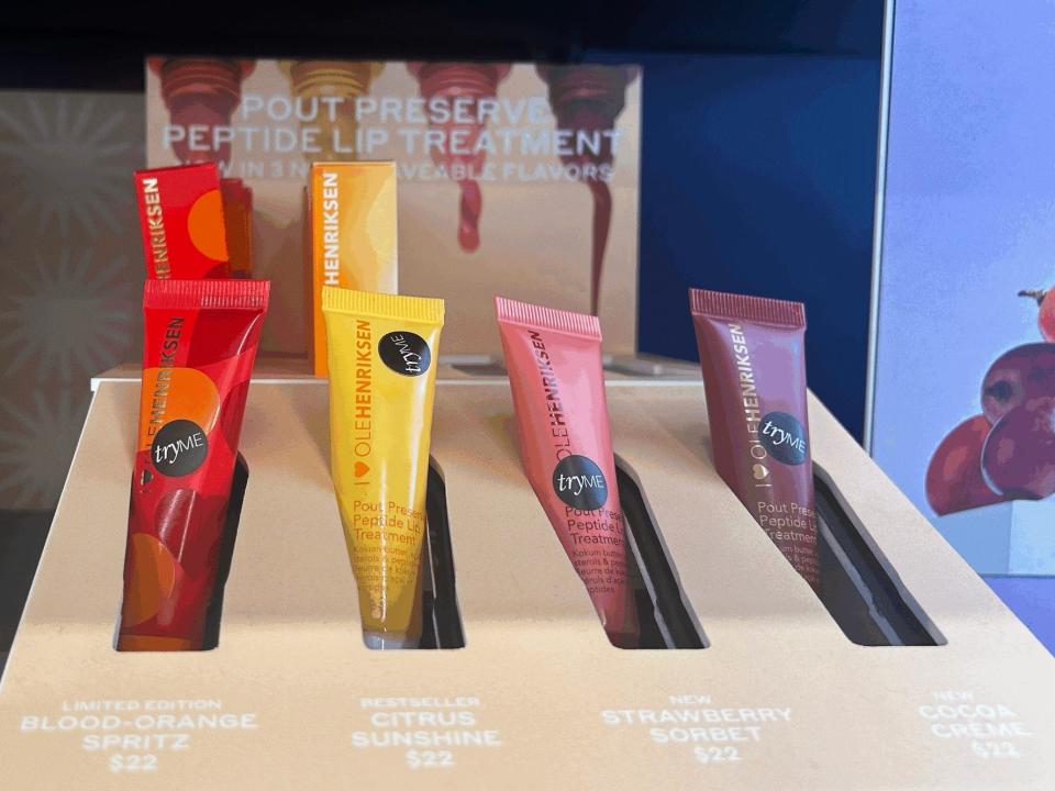 Testers for Ole Henriksen lip treatments. The tubes come in red, yellow, pink, and purple colors and sit on a beige tray