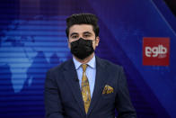 TV anchor Nesar Nabil wears a face mask to protest the Taliban's new order that female presenters cover their faces, as he reads the news on TOLOnews, in Kabul, Afghanistan, Sunday, May 22, 2022. Afghanistan's Taliban rulers have begun enforcing an order requiring all female TV news anchors in the country to cover their faces while on-air. The move Sunday is part of a hard-line shift drawing condemnation from rights activists. (AP Photo/Ebrahim Noroozi)