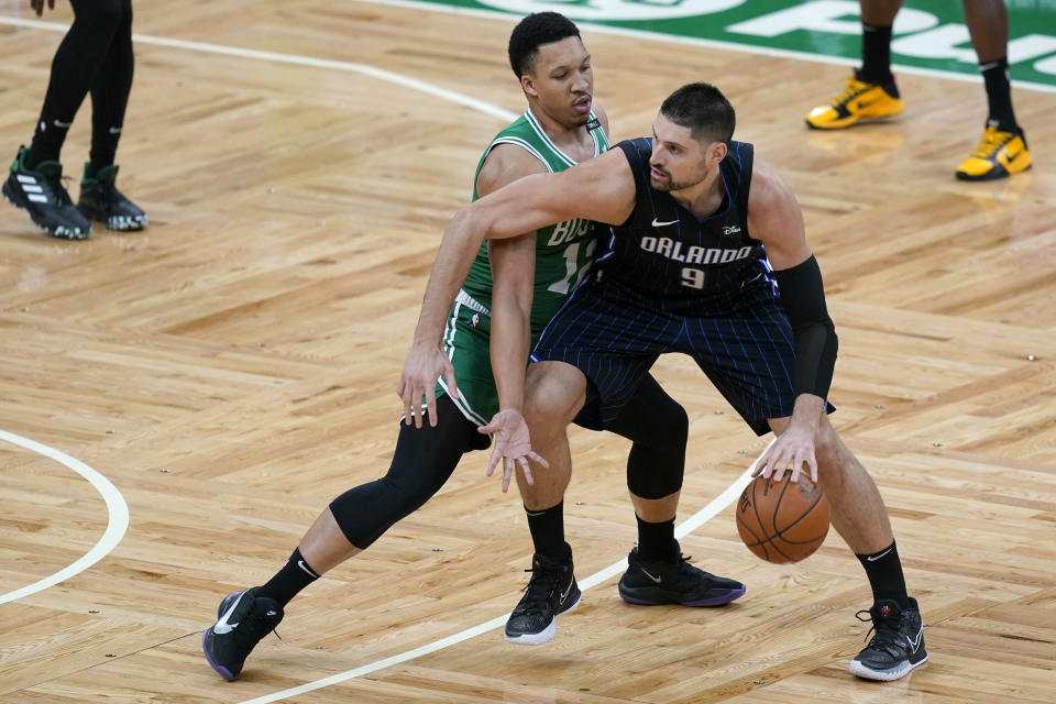 Orlando Magic center Nikola Vucevic (9) dribbles the ball as Boston Celtics forward Grant Williams defends during the first half of an NBA basketball game Friday, Jan. 15, 2021, in Boston. (AP Photo/Elise Amendola)