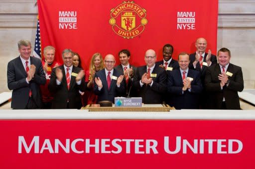 El equipo ejecutivo del Manchester United aplaude tras tocar la campana de apertura de la Bolsa de Nueva York, este viernes. El famoso club inglés de fútbol Manchester United se ha convertido con su ingreso este viernes en el New York Stock Exchange (NYSE) en el equipo deportivo más caro del mundo, a pesar de que debió revisar a la baja sus ambiciones con la venta de acciones a un precio inferior al previsto. (AFP | ben hider)