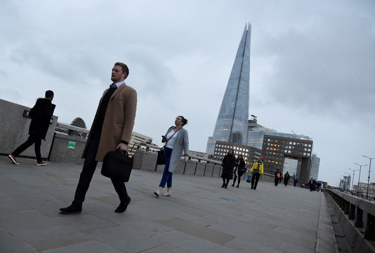 UK economy  Workers cross London Bridge, with The Shard skyscraper seen behind, during the morning rush-hour, as the coronavirus disease (COVID-19) lockdown guidelines imposed by British government encourage working from home, in the City of London financial district, London, Britain, January 4, 2022. REUTERS/Toby Melville