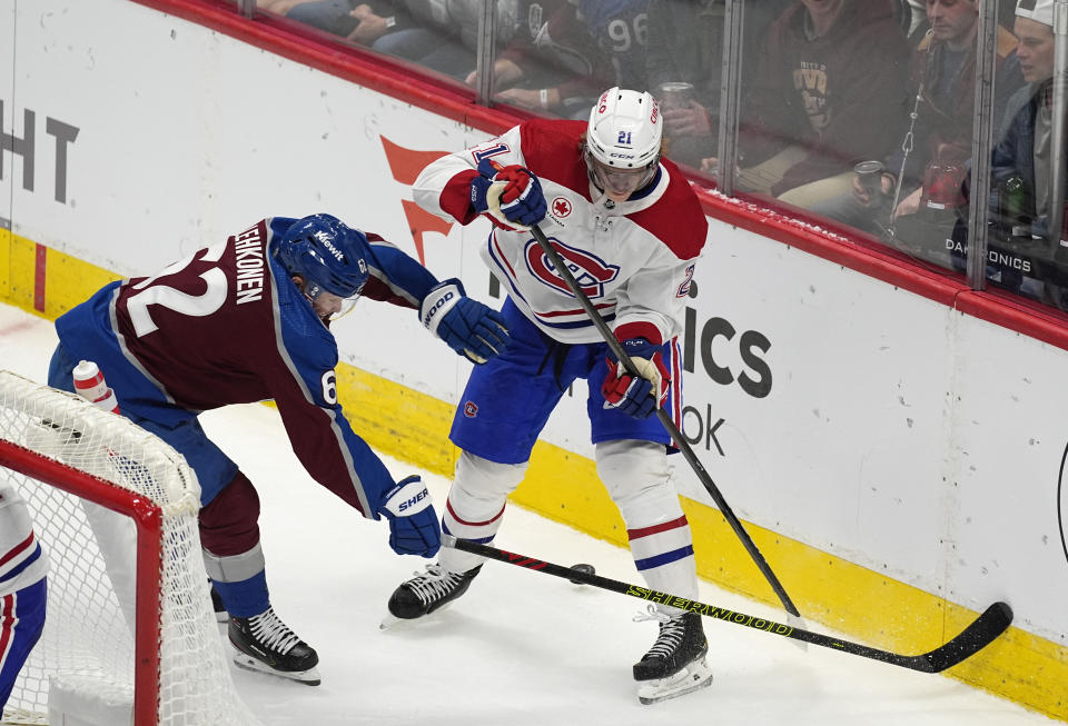 Montreal Canadiens defenseman Kaiden Guhle, right, passes the puck behind him as Colorado Avalanche left wing Artturi Lehkonen defends during the third period of an NHL hockey game Tuesday, March 26, 2024, in Denver. (AP Photo/David Zalubowski)