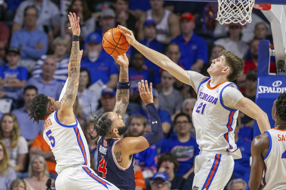 Auburn forward Johni Broome (4) gets his shot blocked by Florida forward Alex Condon (21) and guard Will Richard (5) during the first half of an NCAA college basketball game Saturday, Feb. 10, 2024, in Gainesville, Fla. (AP Photo/Alan Youngblood)