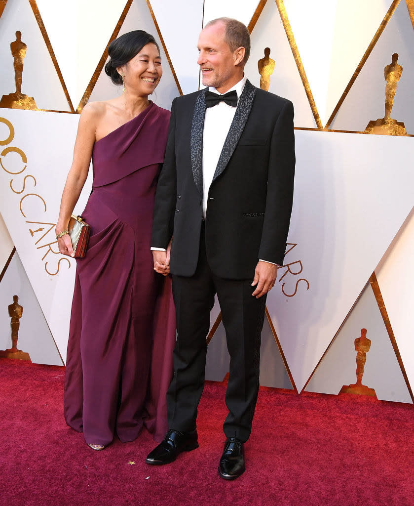 the couple holding hands on the red carpet