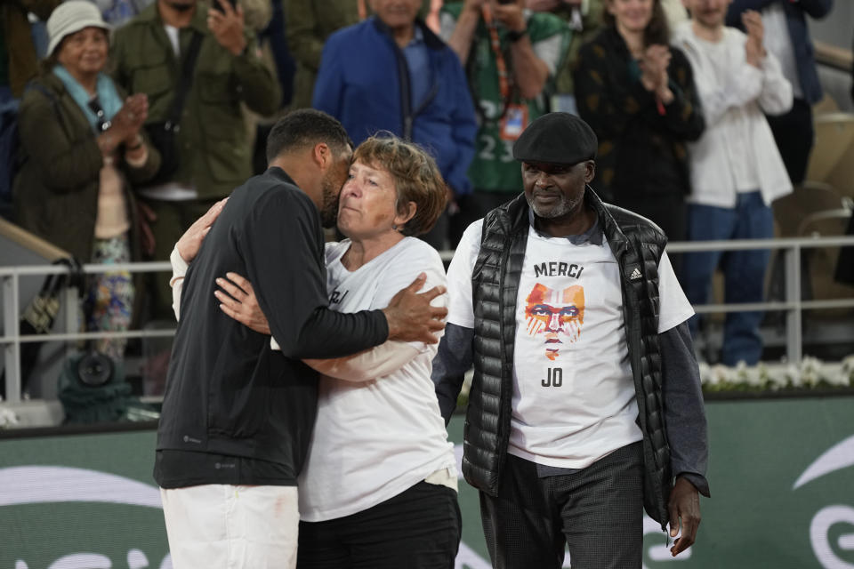 France's Jo-Wilfried Tsonga is kissed by his mother Evelyne Tsonga while his father Didier Tsonga arrives after losing to Norway's Casper Ruud in a first round match of the French Open tennis tournament at the Roland Garros stadium Tuesday, May 24, 2022 in Paris. The Frenchman retired following his first-round loss against Casper Ruud. (AP Photo/Michel Euler)