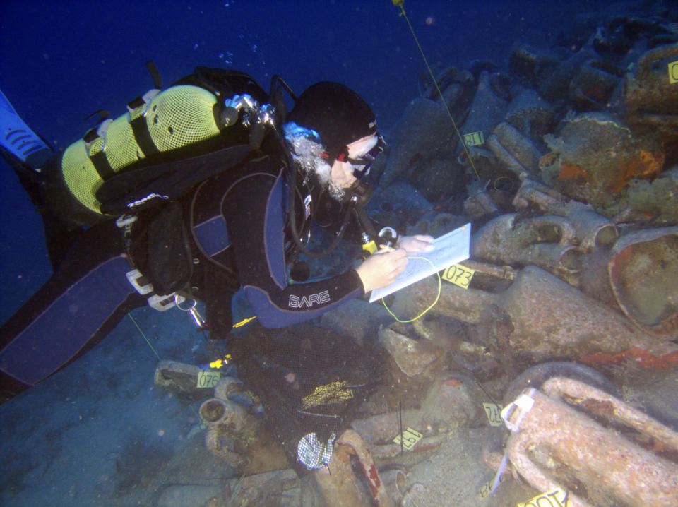 A diver charts large ceramic wine jars, or amphorae, lying on the Mediterranean seabed after the discovery of an ancient shipwreck in the south of Cyprus in this handout picture released June 5, 2008. Archaeologists have started research into what they believe may be the oldest known ancient shipwreck off Cyprus which sank with hundreds of jars of wine on board 2,350 years ago. In what could be described as a super-tanker of ancient times, Cypriot marine archaeologists say it appears to be one of the best preserved wrecks in the region, carrying hundreds of jars of wine dating from the mid-fourth century BC. REUTERS/Department of Antiquities