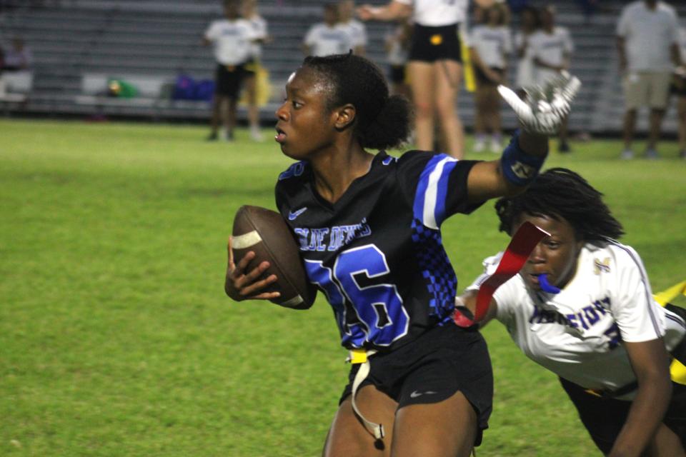 Stanton's Courtney Brown escapes a flag pull attempt on the sideline on her way to a 65-yard touchdown against Menendez during Wednesday's first-round FHSAA playoff.