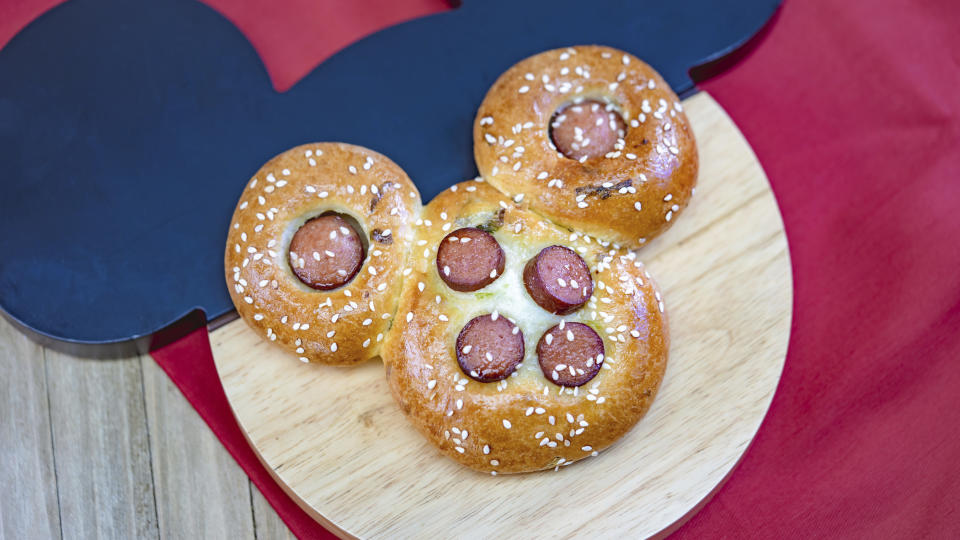 This undated photo provided by Disneyland Resort shows a Mickey Mouse-shaped Chinese hot dog bun from the Prosperity Bao & Buns marketplace at Disney California Adventure Park in Anaheim, Calif. As many Asian-Americans and immigrants across the U.S. mark the Lunar New Year by gathering with family or friends over food, major companies are celebrating, and capitalizing, on the holiday. (Disneyland Resort via AP)