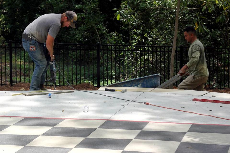 Workers lay the last slabs around Virginia Hylton Park’s outsize checker board on May 3, 2024. Jordan Lawrence/The State